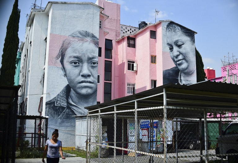 View of building decorated with a mural of Icelandic artist Guido Van Helten  at a poor neighborhood in Ecatepec, Mexico on August 25, 2016.  Dozens of murals were painted on buildings in a poor neighborhood in Ecatepec, on the route of a new cable car that will run this year. / AFP PHOTO / RONALDO SCHEMIDT / TO GO WITH AFP STORY BY JENNIFER GONZALEZ